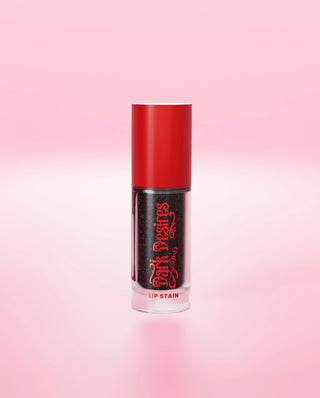 A black P.Louise colour-changing lip stain with red cap on a pink background