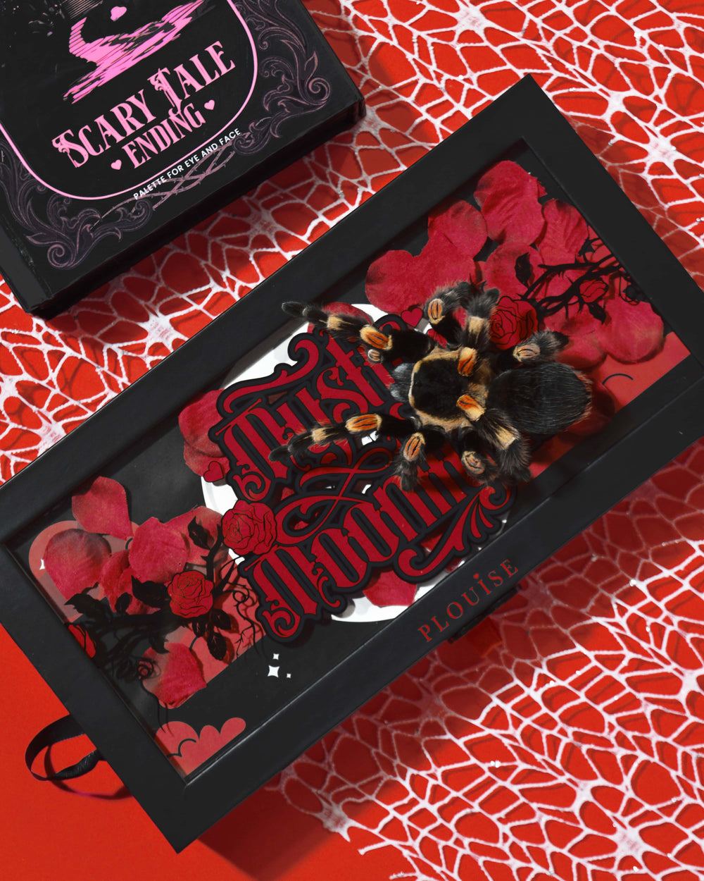 Κουτί παλέτας σκιών ματιών P.Louise Mystic Moonlight Halloween καλυμμένο με κόκκινα ροδοπέταλα και μια ταραντούλα σε φόντο κόκκινο ιστό αράχνης