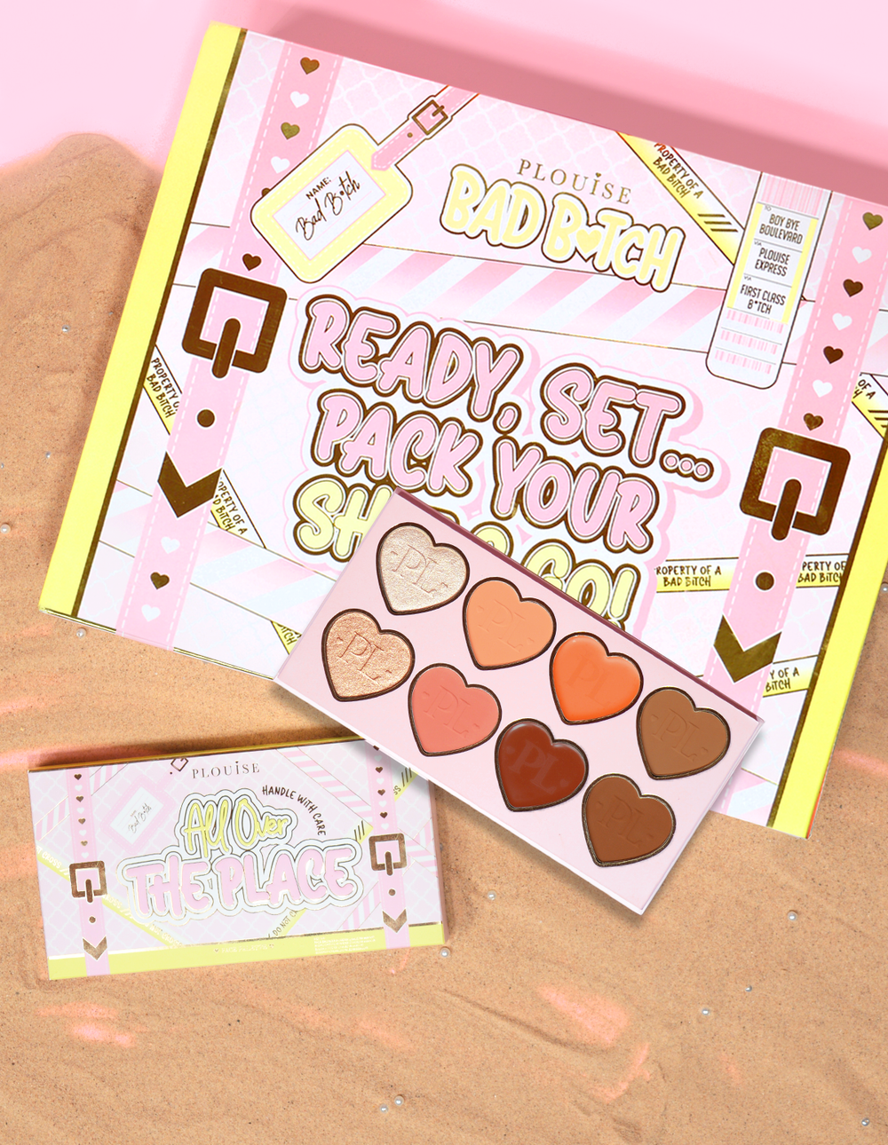 Συσκευασία και προϊόν P.Louise All Over The Place Face Palette με αποχρώσεις ταψιού σε σχήμα καρδιάς σε διάφορα χρώματα σε ένα κρεβάτι άμμου.