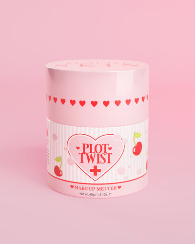 Ένα ροζ δοχείο P.Louise Plot Twist Makeup Melting Cleansing Balm με σχέδια καρδιά και κεράσι στην ετικέτα σε ροζ φόντο