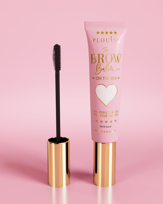 P.Louise Soap Brow Balm product in a pink tube with a golden cap, accompanied by a black eyebrow brush, displayed against a pink background.