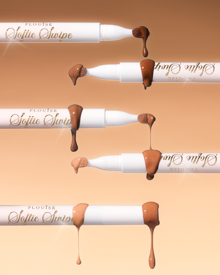Μια εικόνα από πέντε P.Louise Softie Swipe Tinted Lip Masks με το προϊόν να στάζει από τις άκρες που δείχνουν τις διάφορες αποχρώσεις σε μπεζ φόντο
