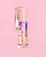 P. Louise Soak Me Lip Oil με πολύχρωμο λαδάκι σε ροζ σωλήνα με χρυσό κούμπωμα σε ροζ φόντο