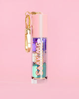 P. Louise Soak Me Lip Oil με πολύχρωμο λαδάκι σε ροζ σωλήνα με χρυσό κούμπωμα σε ροζ φόντο
