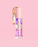 P. Louise Soak Me Lip Oil με πολύχρωμο λαδάκι σε ροζ σωλήνα με χρυσό κούμπωμα σε ροζ φόντο