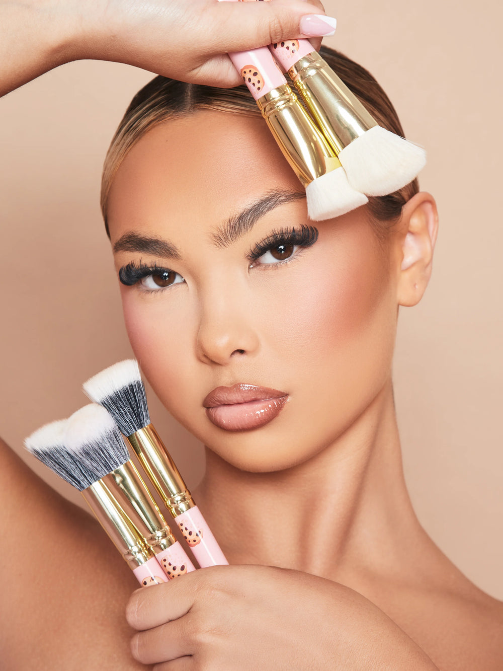 An image of a woman model wearing makeup holding the P.Louise Spoilt For Choice 5-Piece Makeup Brush Set against her face