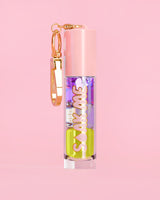 P. Louise Soak Me Lip Oil με πολύχρωμο λαδάκι σε ροζ σωλήνα με χρυσό κούμπωμα σε ροζ φόντο